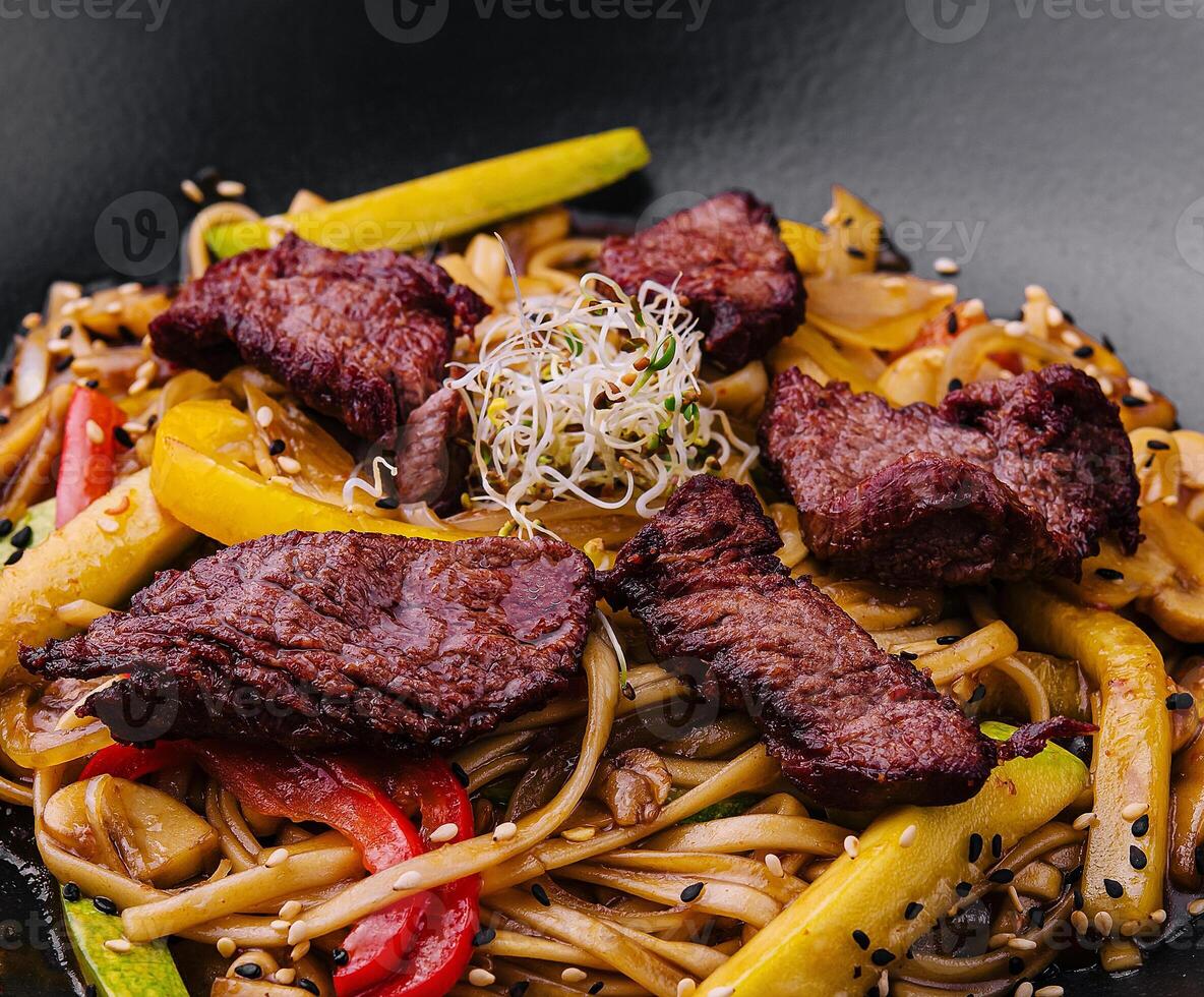 Chinese noodles with roasted duck and fried vegetables photo