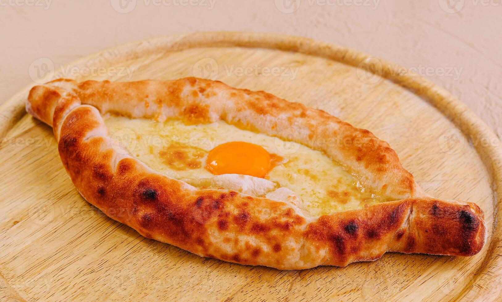Ajarian Khachapuri, filled with cheese and topped with egg yolk photo