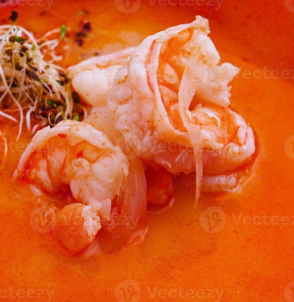 Traditional Thai soup Tom Yam in black bowl photo