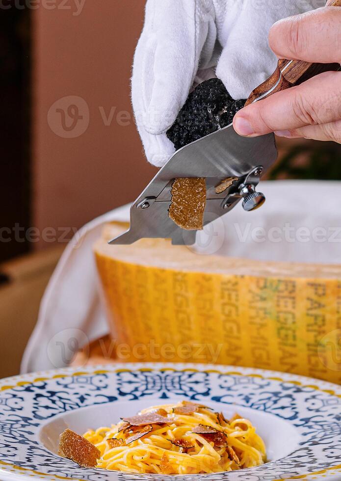 Chef Grating Truffle Shavings on Pasta with Parmesan photo