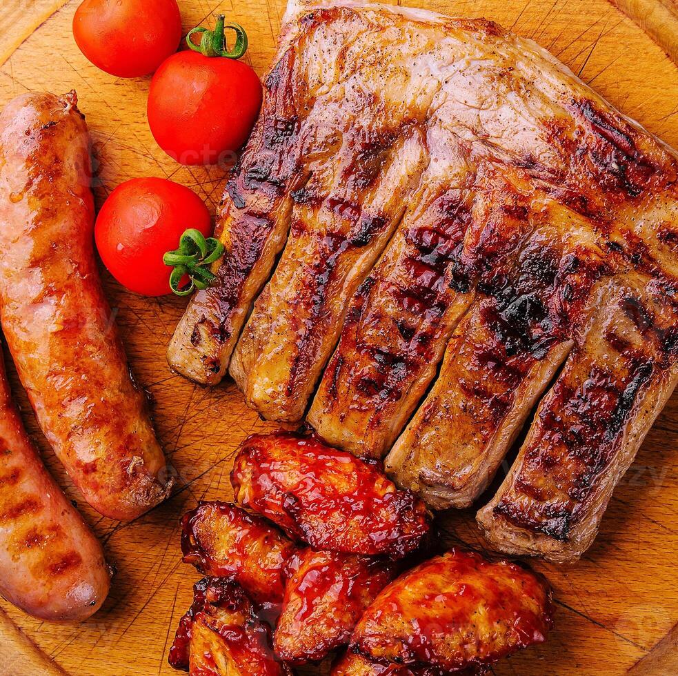 Cerdo costillas con pollo y salchichas en de madera tablero foto