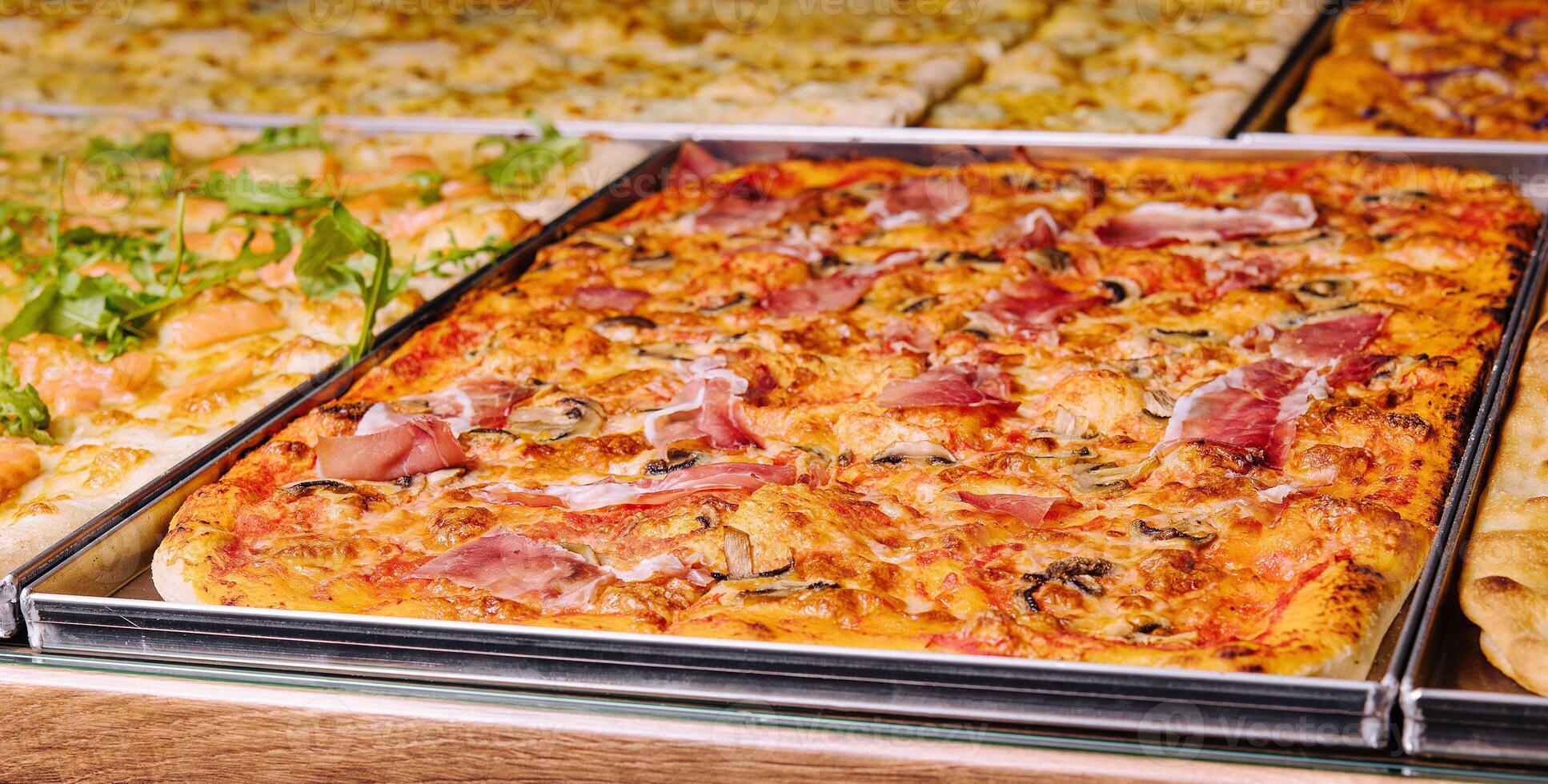 Tasty square pizzas on metal trays photo