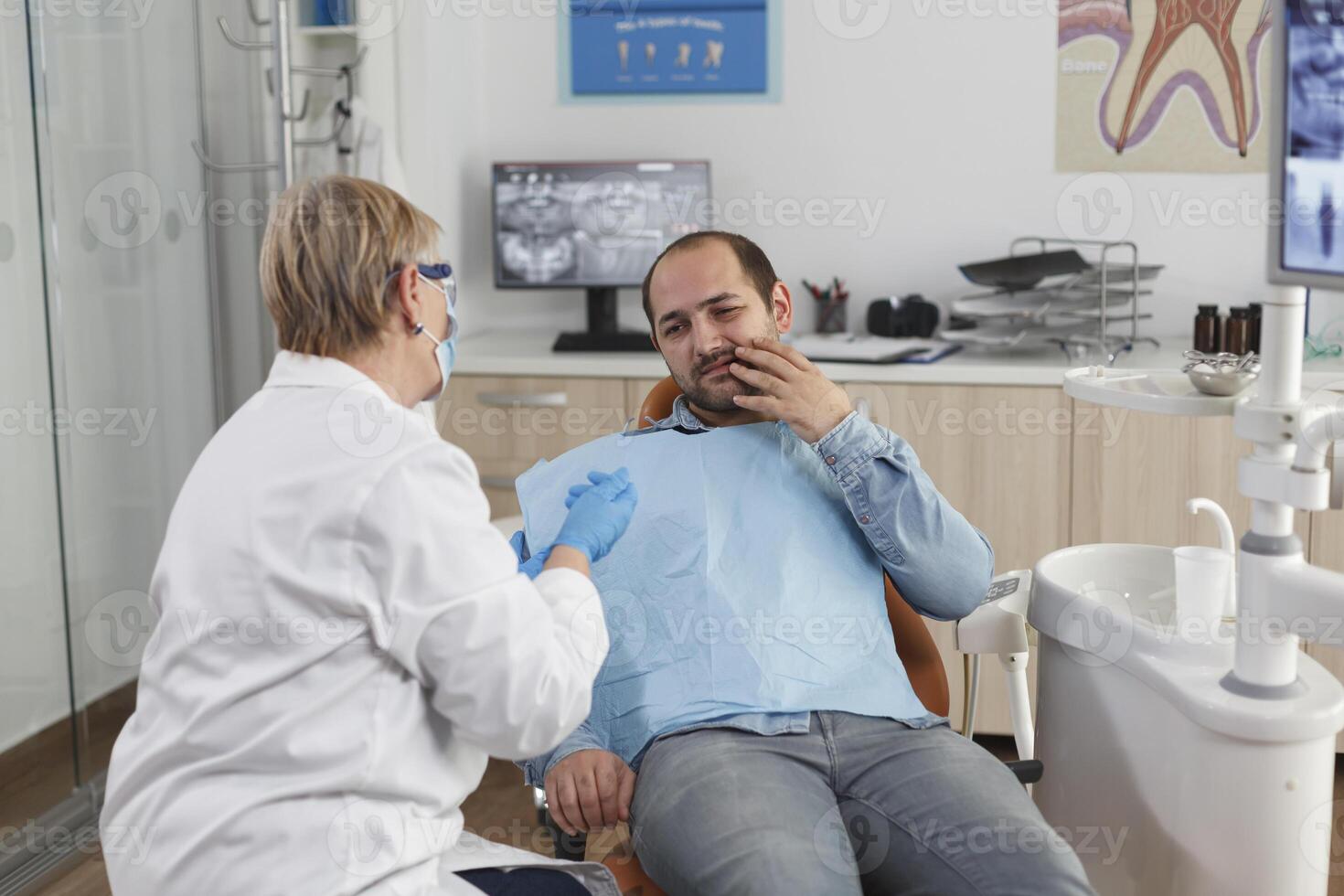 Dentist doctor explaining oral hygiene to patient with toothache discussing healthcare treatment during stomatological consultation in dental office room. Concept of medicine service photo