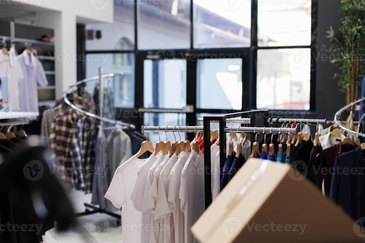 Interior of modern fashion store with stylish clothes on racks, fashionable brand design and formal wear in boutique. Empty clothing showroom in shopping mall with elegant merchandise. photo