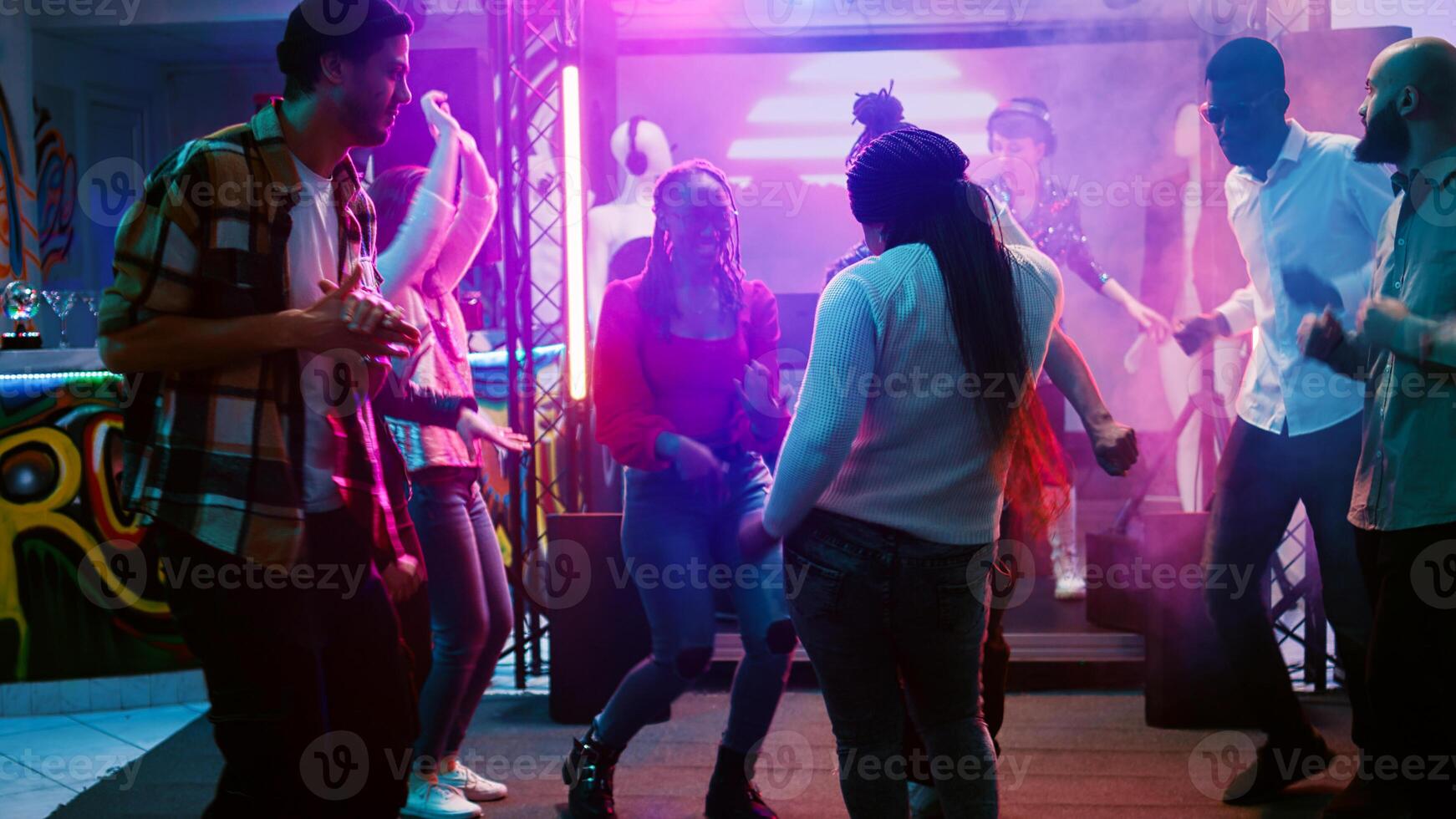 hembra bailarín ir de fiesta a Club nocturno, demostración miedoso danza se mueve en electrónico música a fiesta. joven personas teniendo divertido juntos con disco luces en danza piso, celebracion. Mano disparo. foto