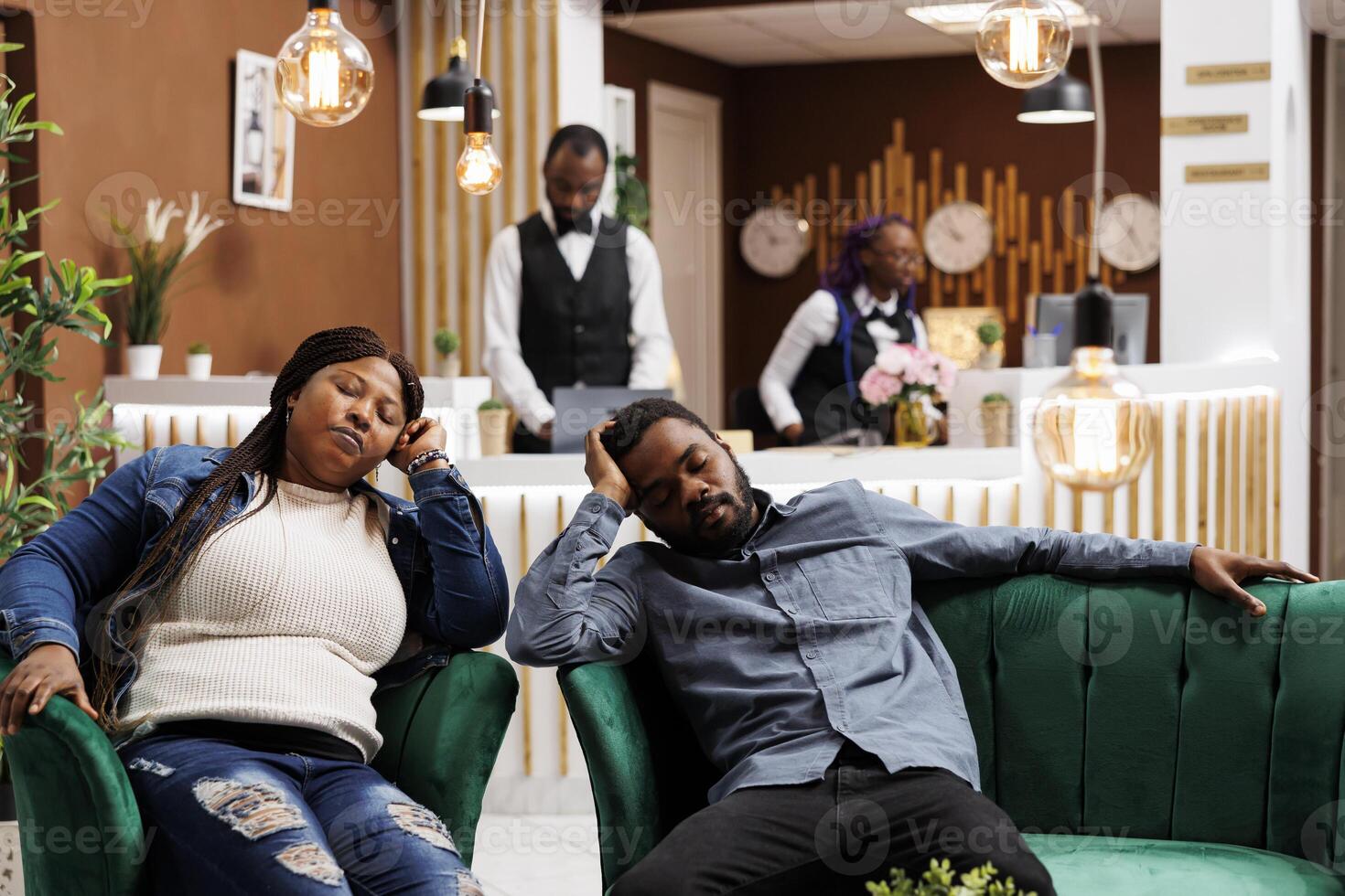 Jet lag. Tired exhausted African American tourists sleeping in hotel lobby after long-distance plane travel, black couple falling asleep while waiting for check-in at reception area photo