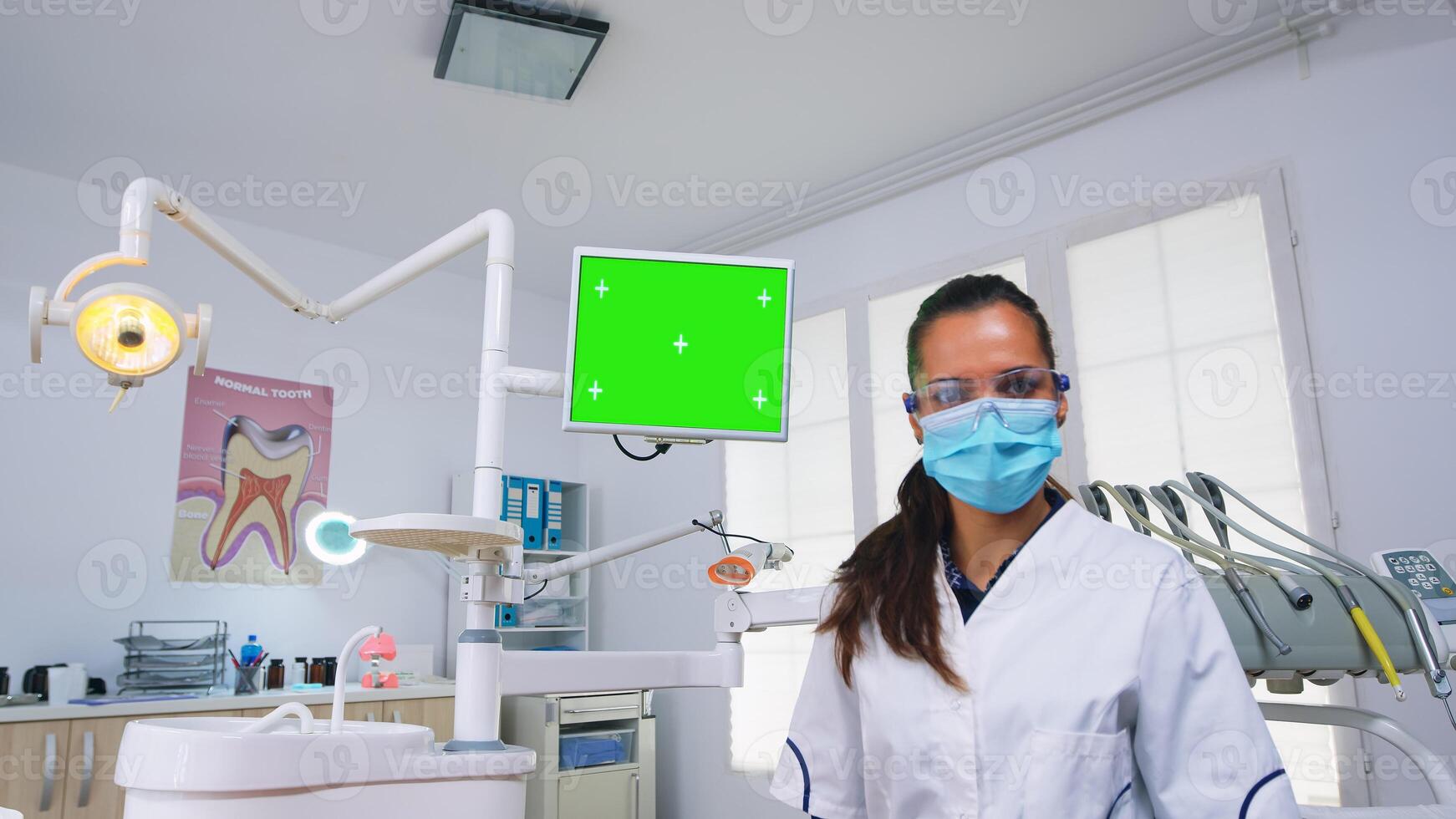 paciente pov de dentista explicando dental problema y diagnóstico para dientes infección utilizando monitor unidad con verde pantalla. estomatología especialista señalando a Bosquejo, Copiar espacio, croma monitor foto