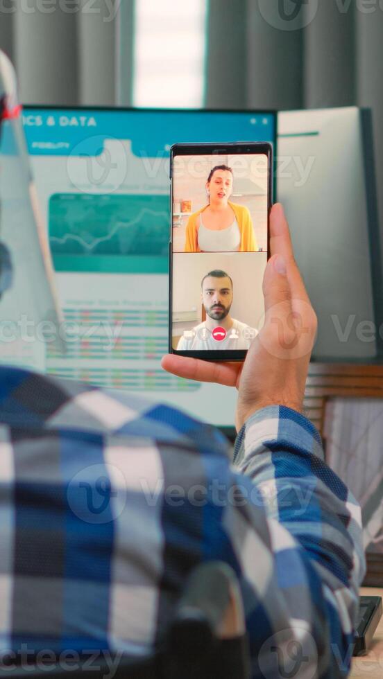 Finance freelancer with disability in wheelchair having videocall during coronavirus outbreak in new normal business office. Immobilized, businessman working in company respecting social distance. photo