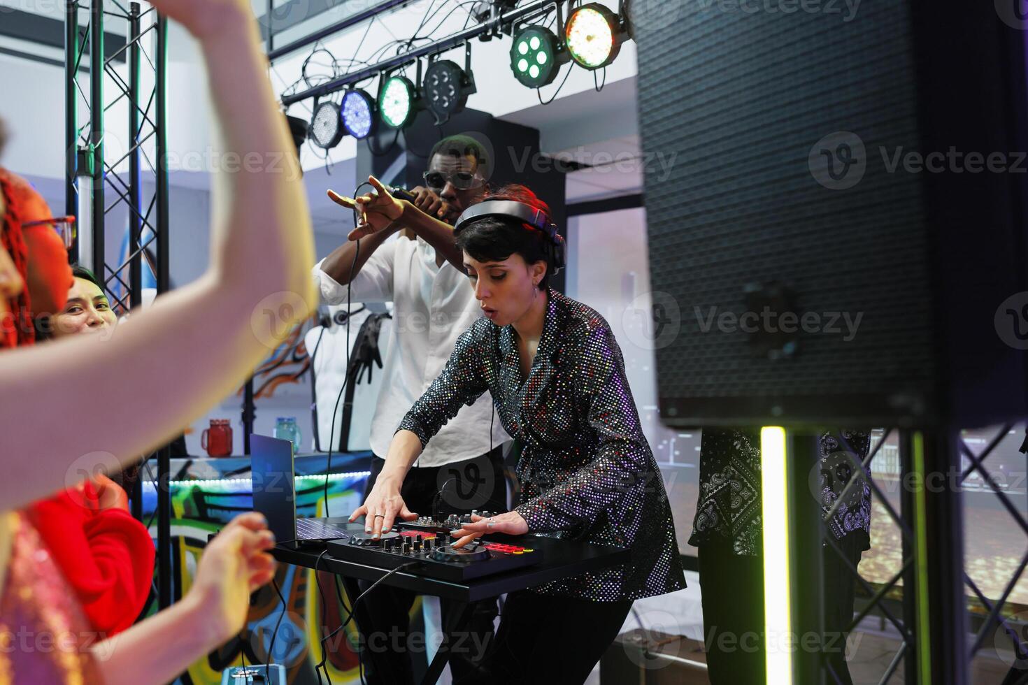 banda frontwoman utilizando DJ estación mientras cantante ejecutando con micrófono en etapa a Club nocturno fiesta. músicos jugando electrónico música para clubbers a En Vivo concierto en club foto