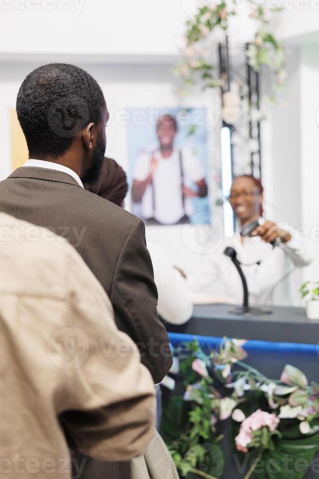 Clothing store clients standing in queue to pay for purchase at cash register. Shopping mall african american customers waiting for assistant to scan apparel at counter desk photo