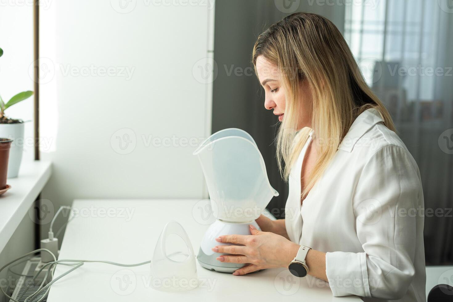 joven mujer haciendo inhalación con un médico vaporizador nebulizador máquina en negro antecedentes foto