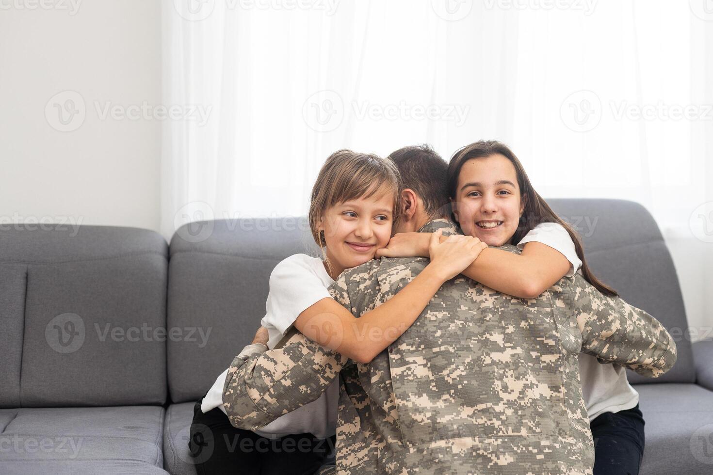 happy positive smiling soldier man in camouflage sitting with his daughter on sofa, looking how his kid grown when he was in army, returning home from war. photo