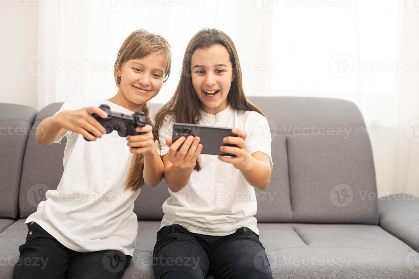 Two middle school girls at home playing an exciting video game together. photo