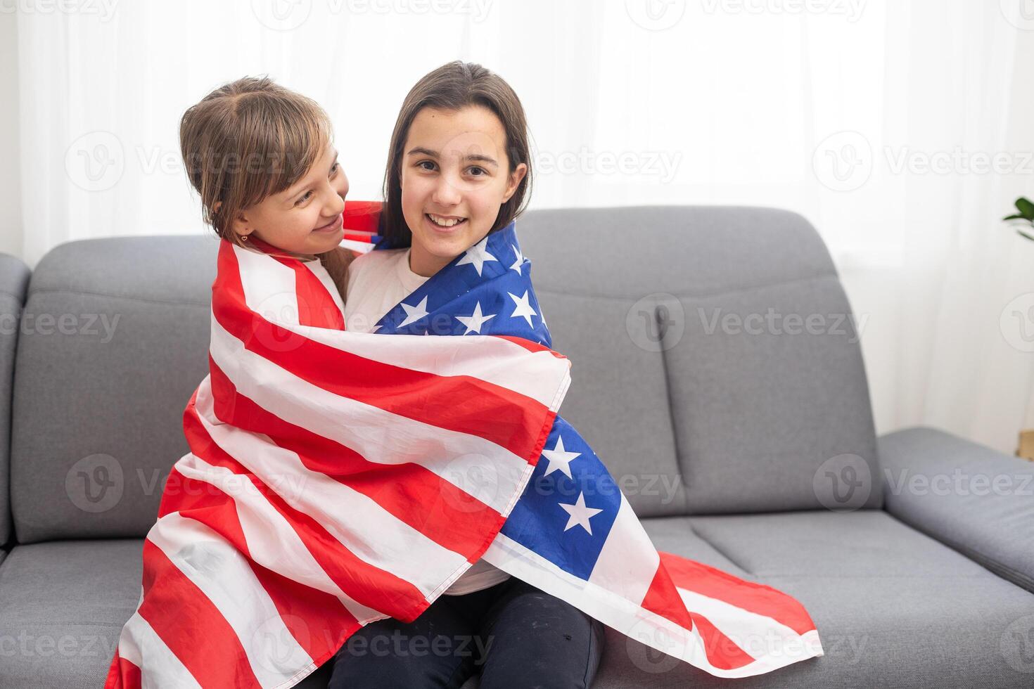 Two sisters with American flag on grey background photo