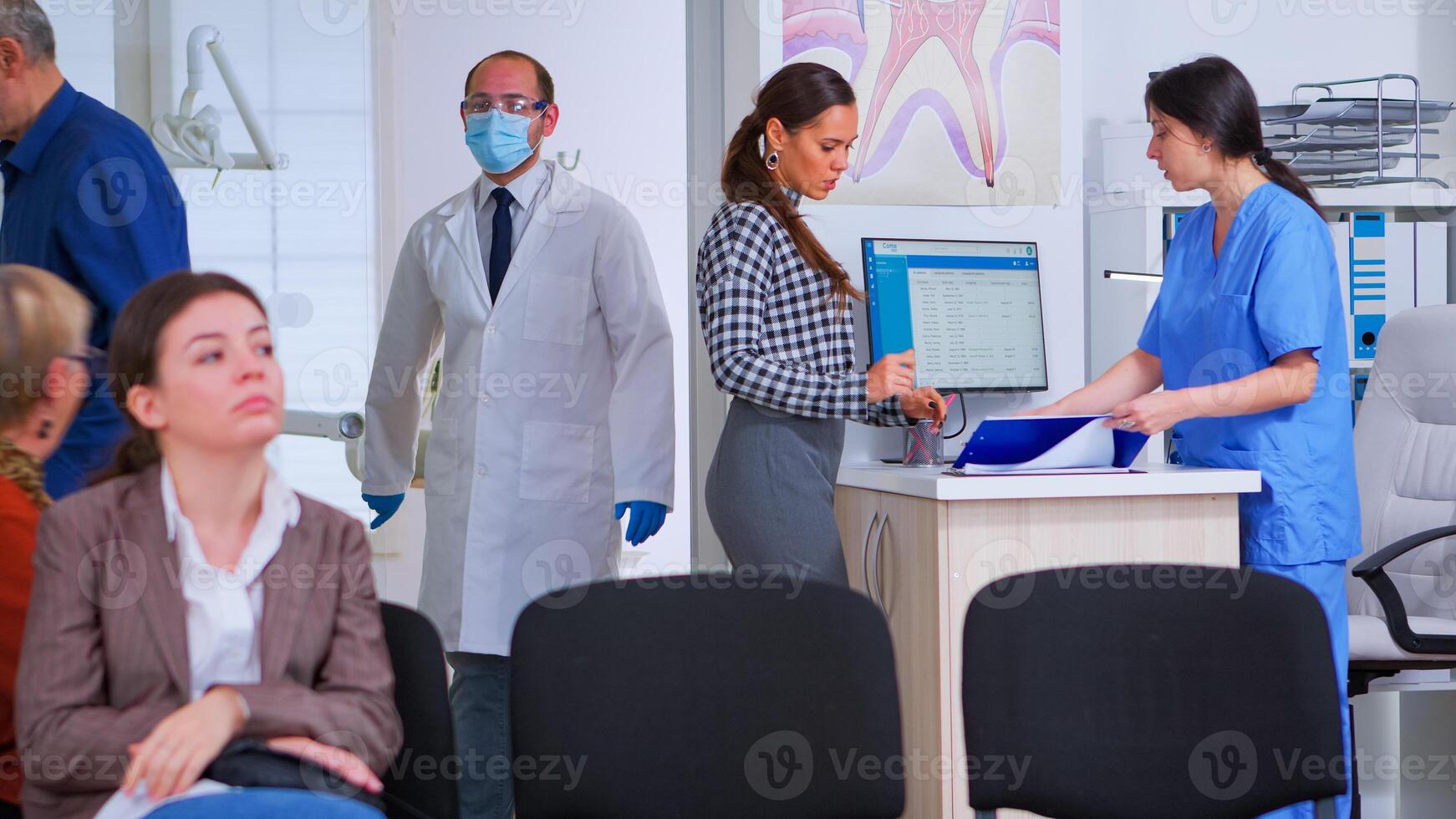 Woman coming at dental office asking for appointment sitting on chair in waiting room writing on registration document in stomatomoly clinic. Patients stitting in crowded orthodontist reception office photo