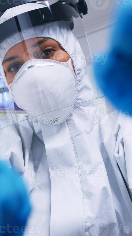 Pov of dentist in ppe suit against covid working on patient mouth hygine in dental office with new normal. Stomatolog wearing safety gear against coronavirus during heatlhcare check of patient. photo