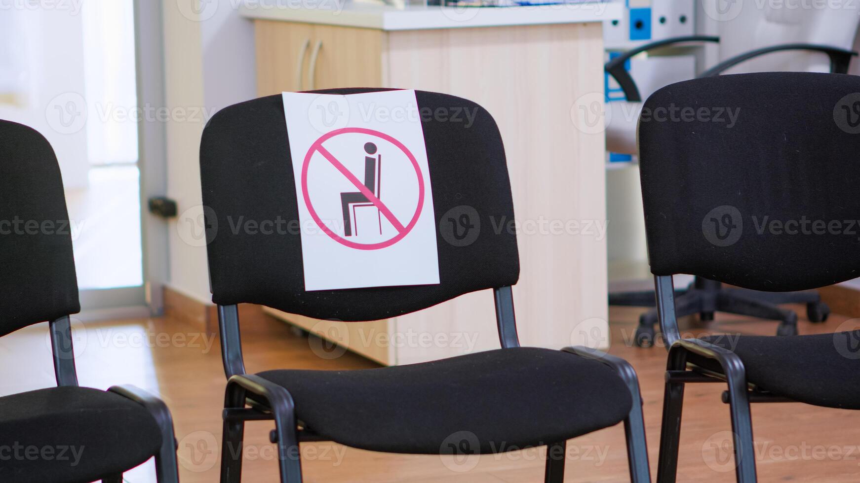 Waiting room in clinic with nobody in it, front office with new normal having sign on chair for social distance in coronavirus pandemic. Empty stomatology reception during covid-19 epidemic. photo