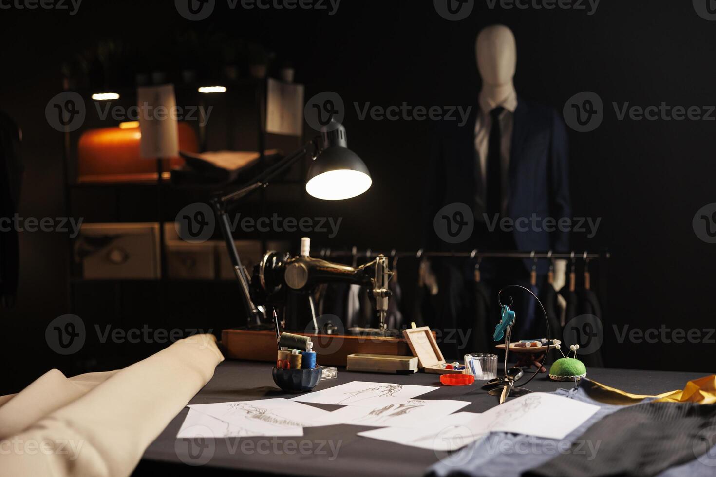 Exquisite professional tailoring studio full of premium quality bespoken sartorial collection and fashion design sketch drawings on walls. Atelier shop with stylish elegant clothing on mannequins photo