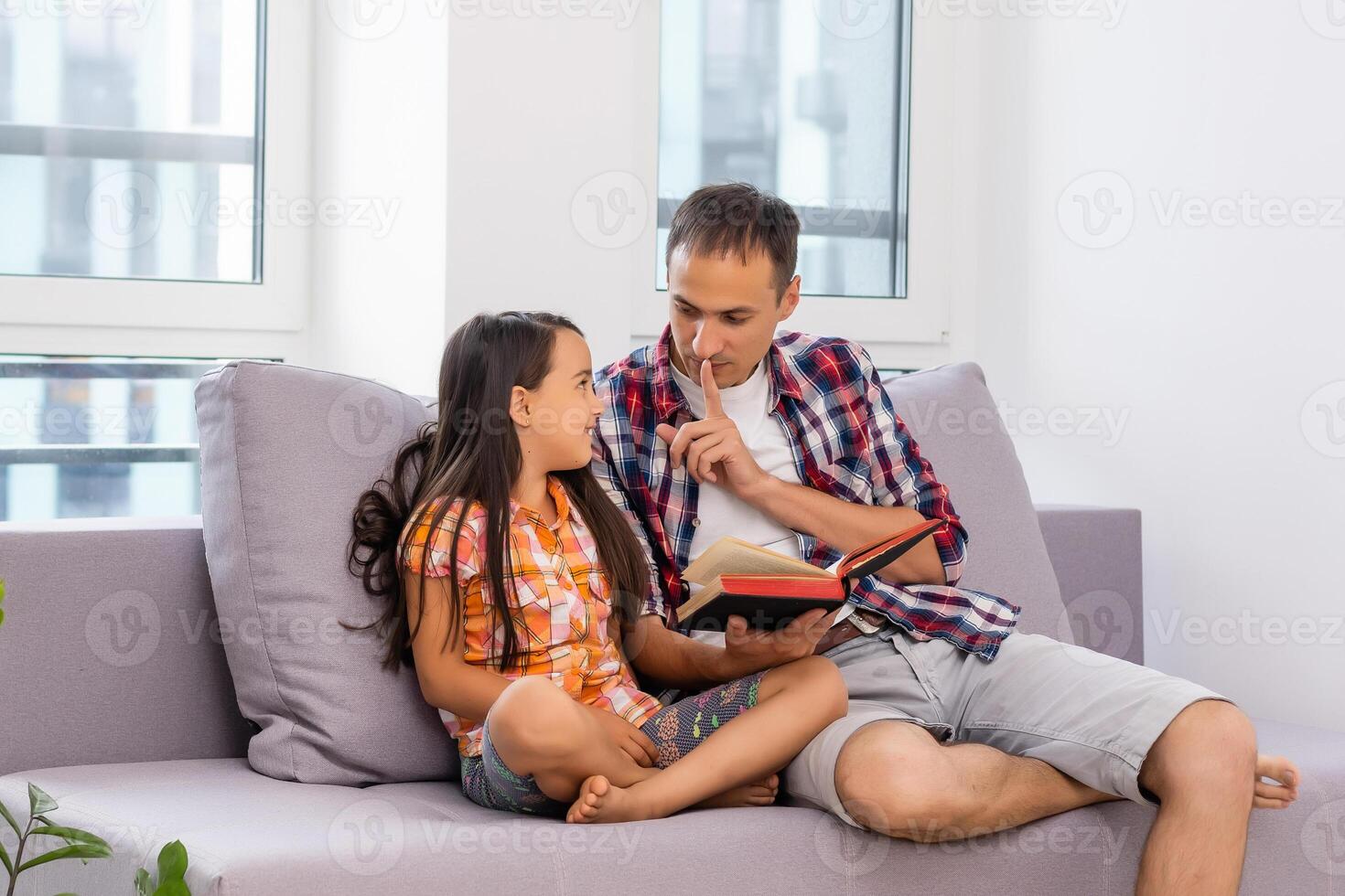 a young father with his little daughter reads the Bible photo