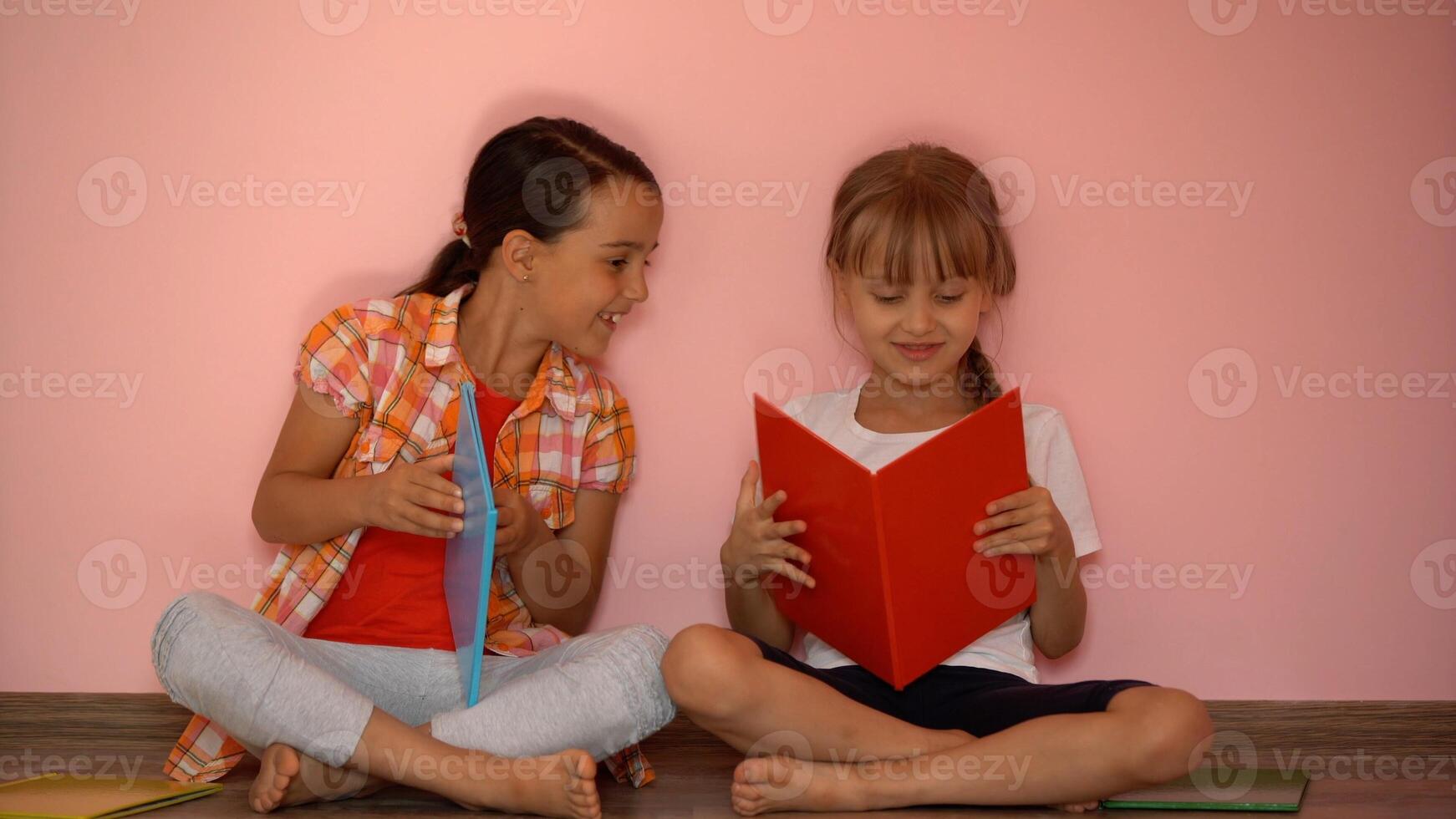 education and school concept - little student girls studying and reading book at home photo