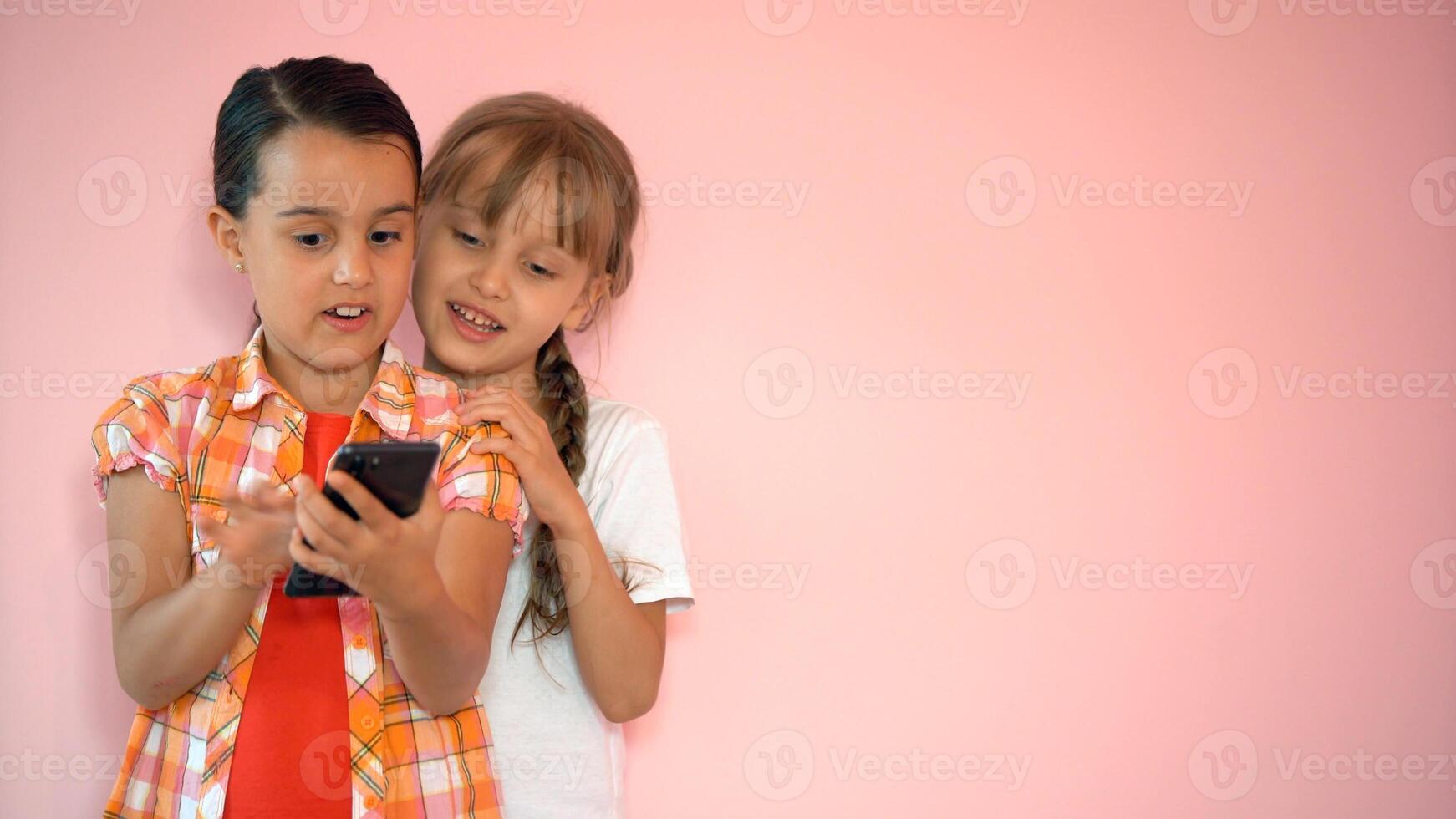 two little girls taking photo with a smartphone