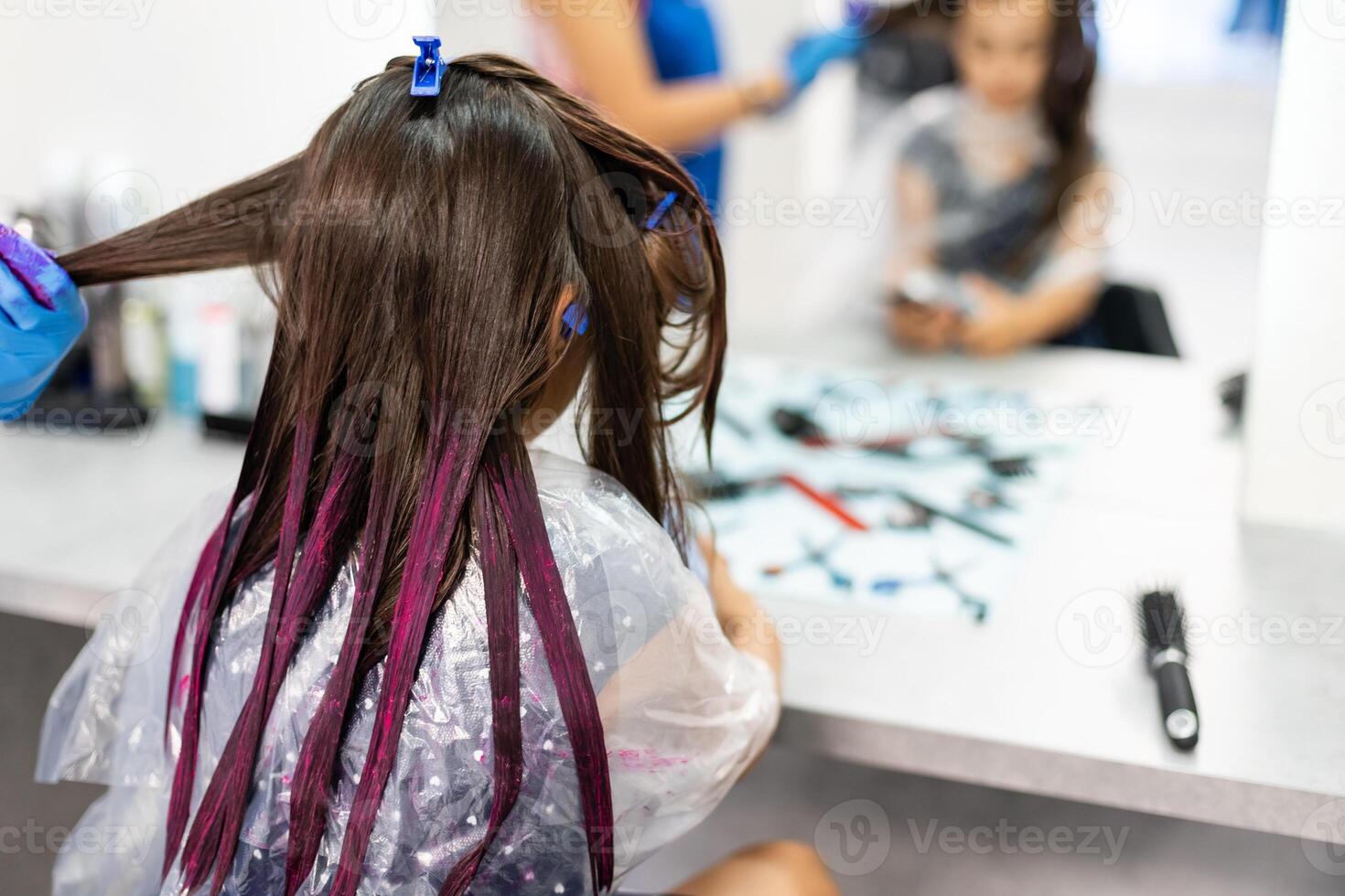 hairdresser dyes hair for a little girl in a hair salon. Dyed, bleached hair photo