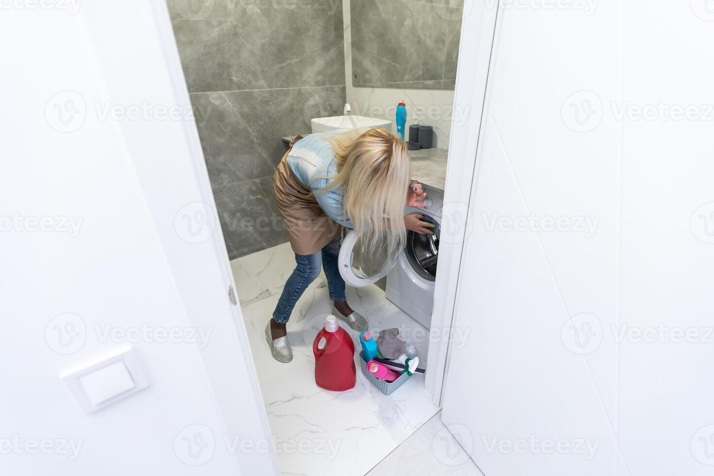 Beautiful young woman cleaning bathroom photo
