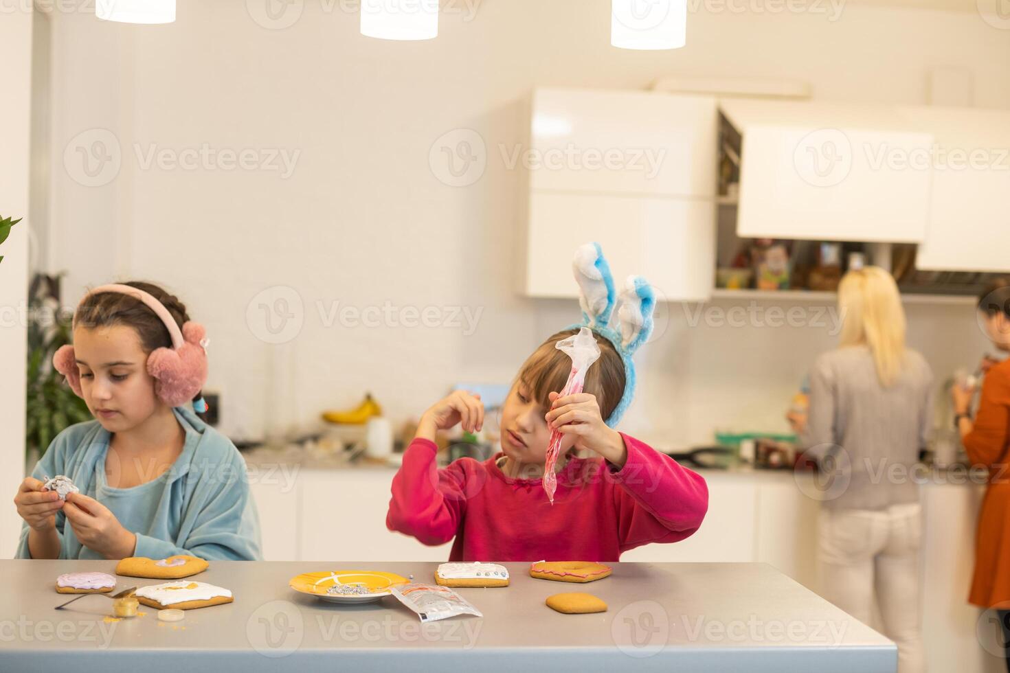 Portrait of happy small children decorating homemade cookies in kitchen and making xmas cookies together at home photo