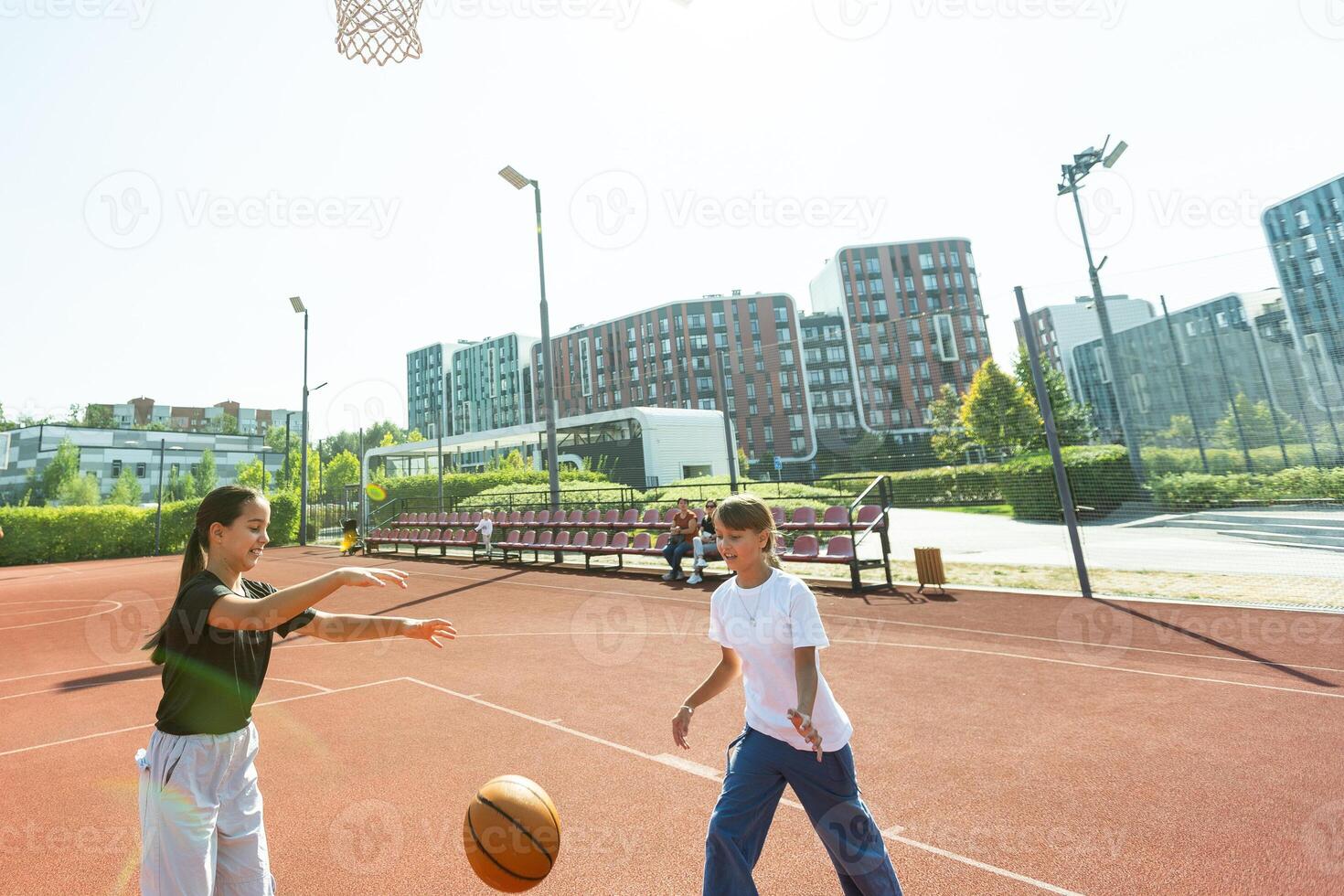 adolescente niña calle baloncesto jugador con pelota en al aire libre ciudad baloncesto corte. foto