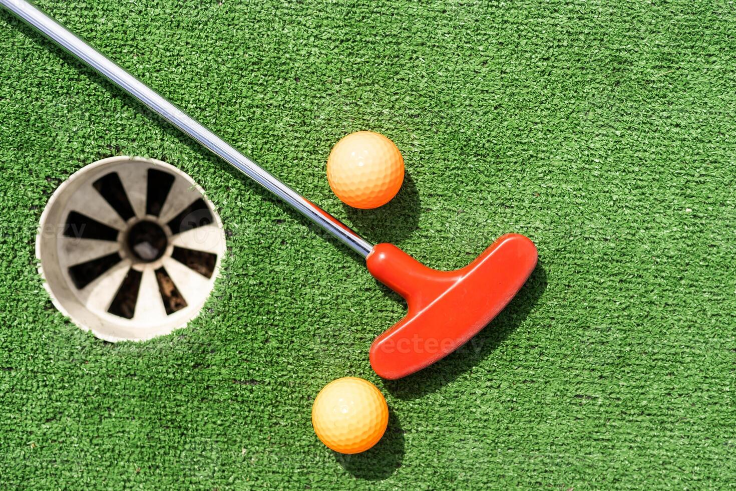 Golf stick and ball on green grass close up. photo