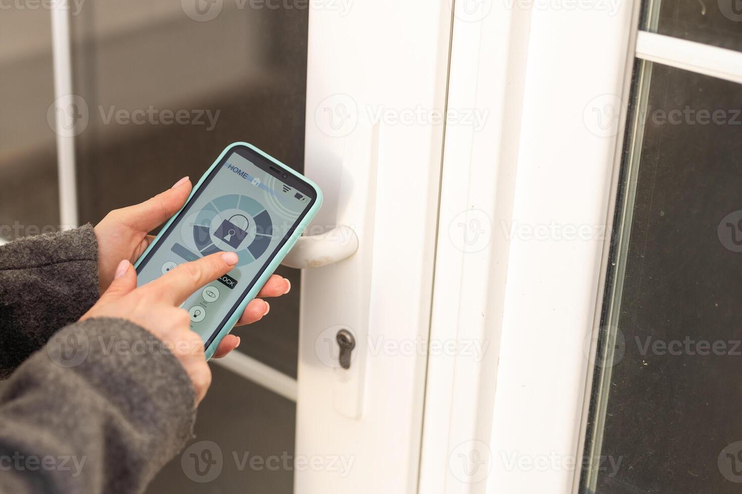 Smiling woman setting home security system with help of mobile application. photo