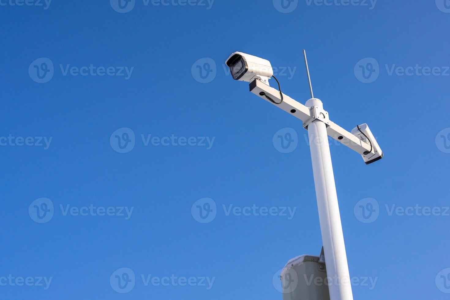 Security camera cover with ice and snow against blue sky background photo