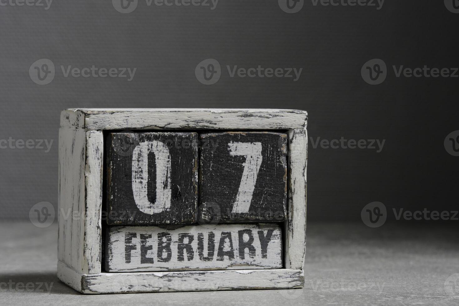 February 07 on wooden calendar, on dark gray background. photo