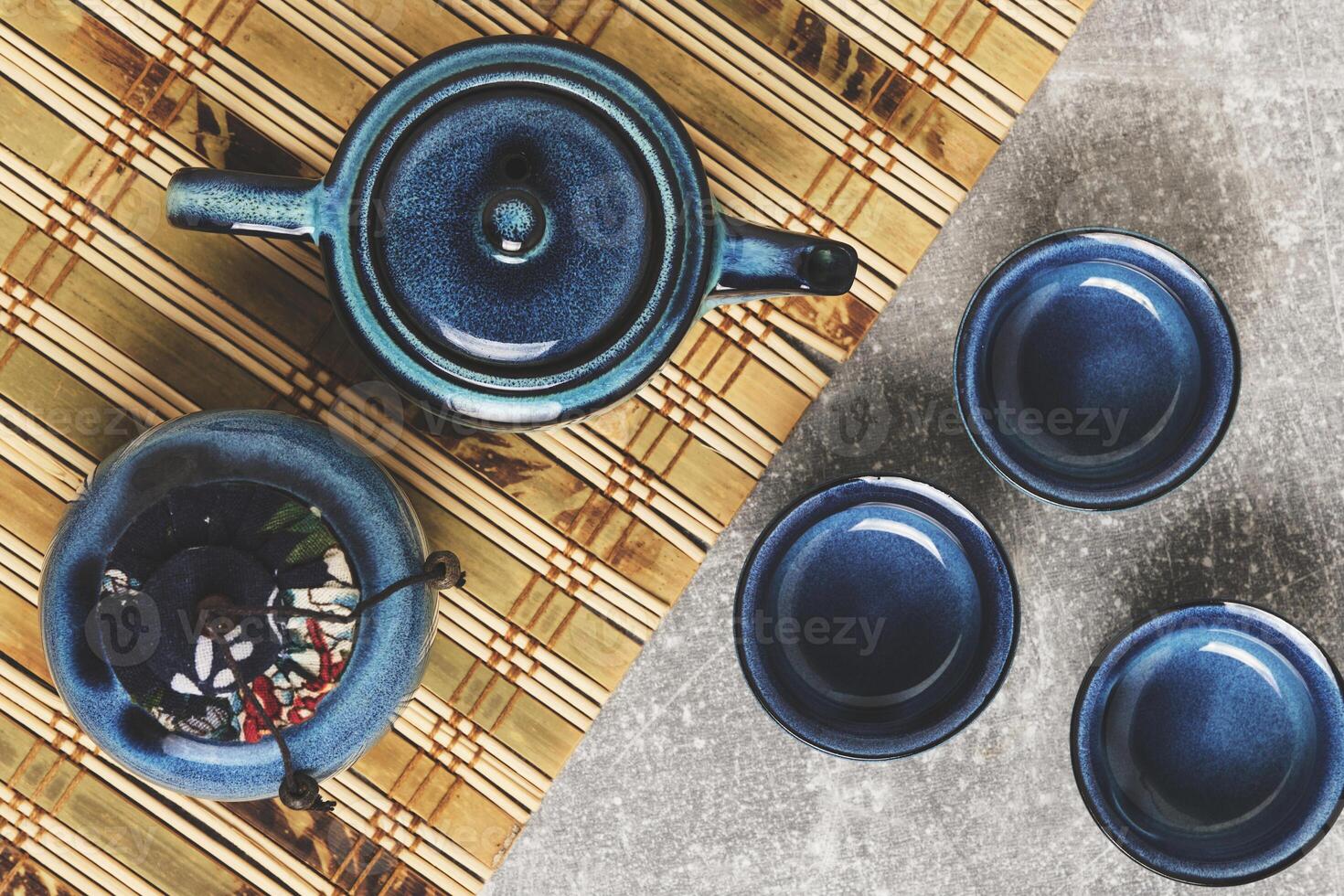 Tableware for tea ceremony top view. Blue tea set pottery on bamboo napkin. photo