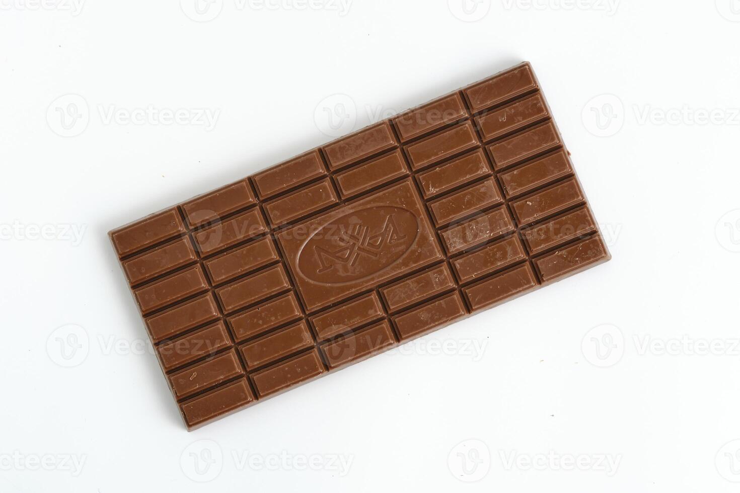 Bar of milk chocolate white background. photo