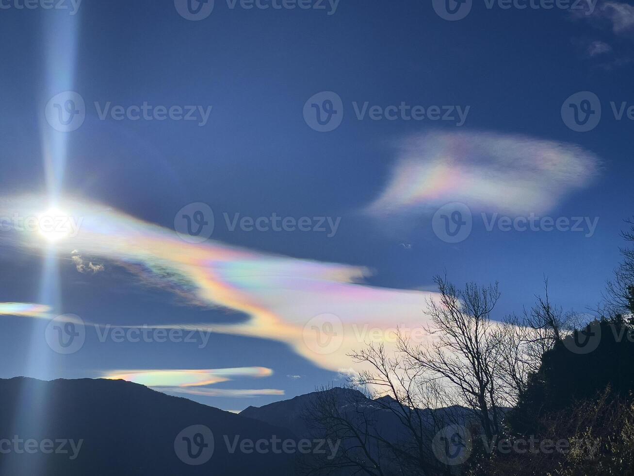 rainbow clouds in the sky with mountains in the background photo