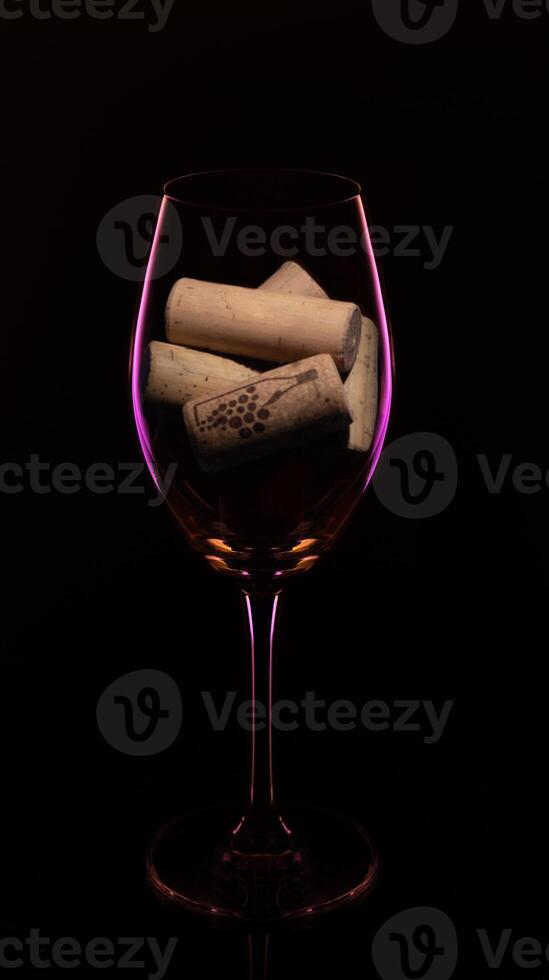 a glass of wine with corks in it photo