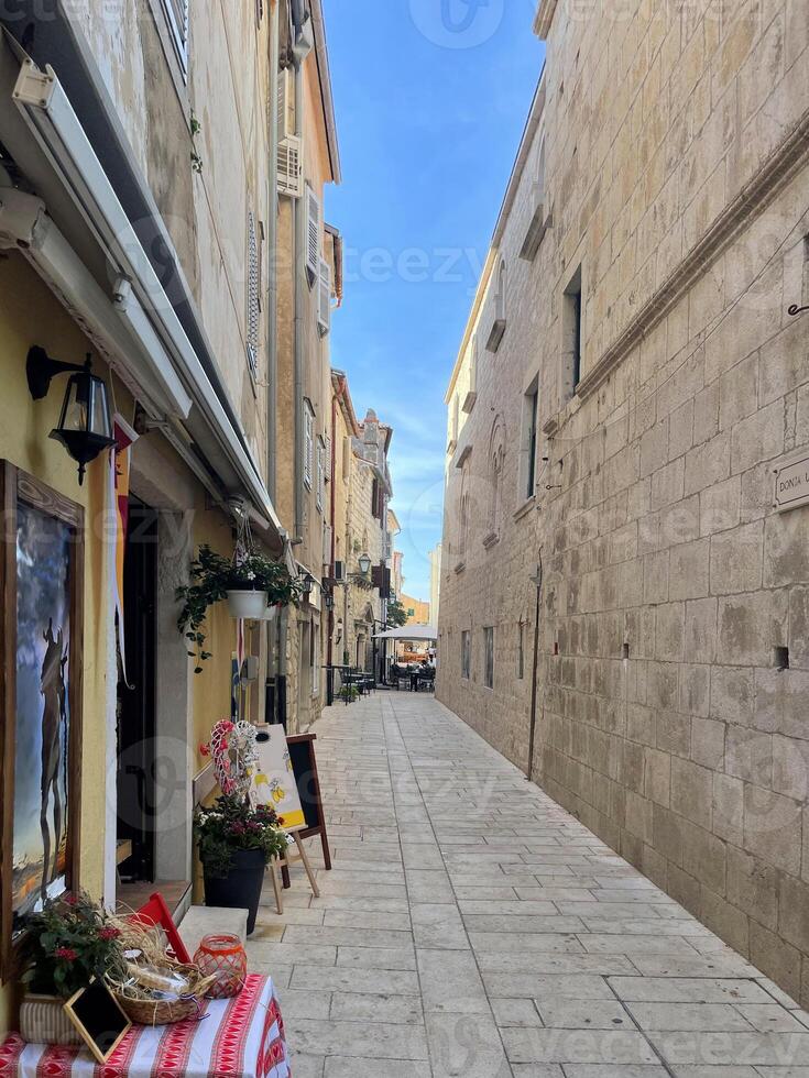 a narrow street with a table and chairs in it photo