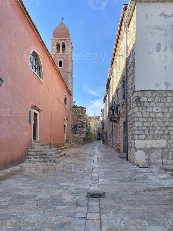 a narrow street with a clock tower in the middle photo