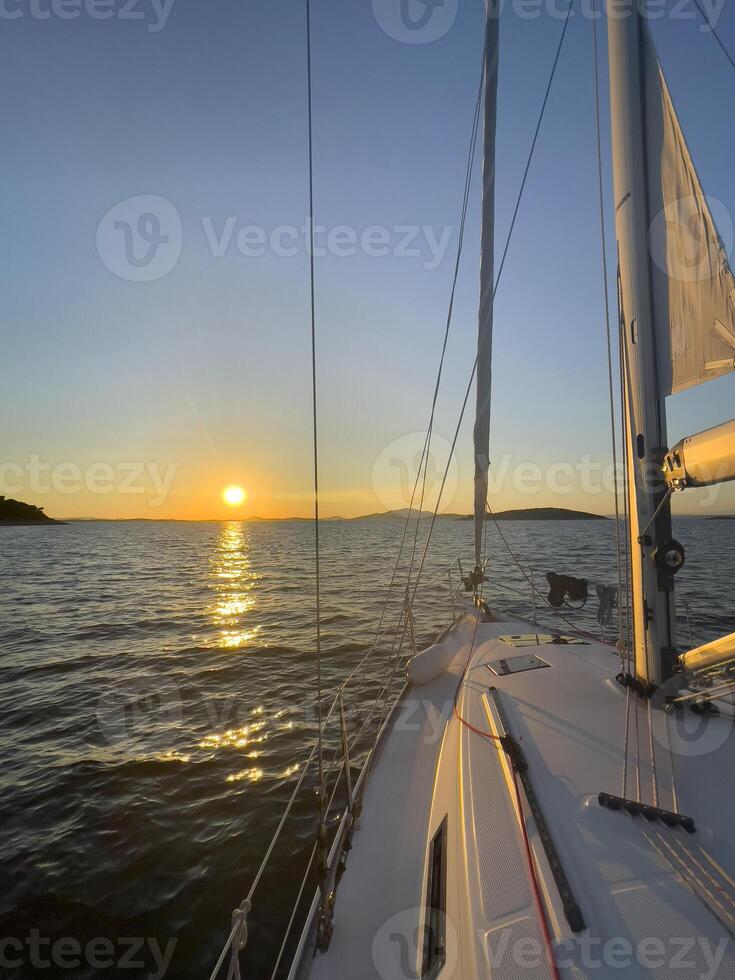 a sailboat is sailing at sunset photo