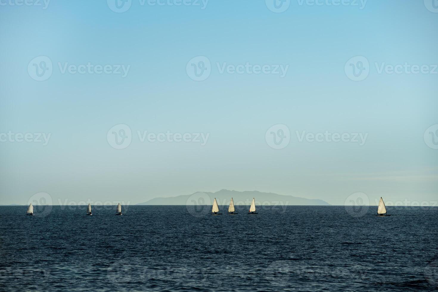 Small sailboats sailing on the ocean photo