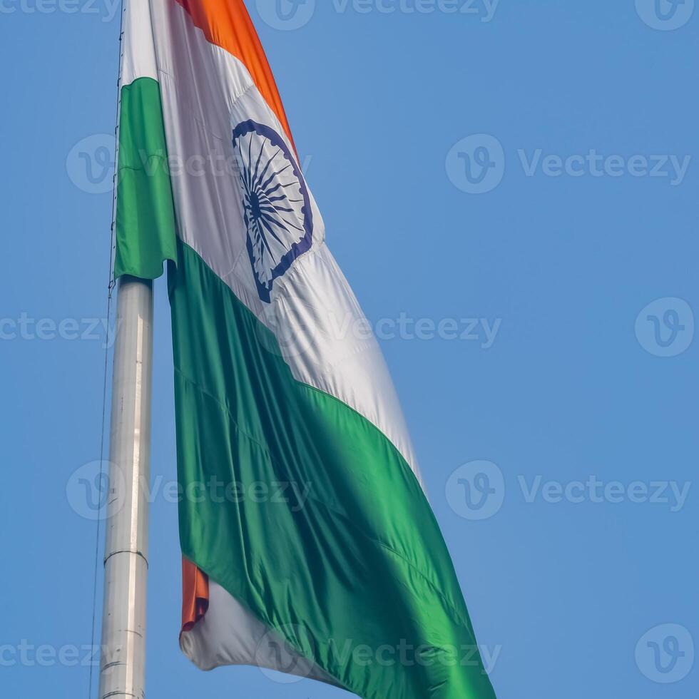 India flag flying high at Connaught Place with pride in blue sky, India flag fluttering, Indian Flag on Independence Day and Republic Day of India, tilt up shot, Waving Indian flag, Har Ghar Tiranga photo