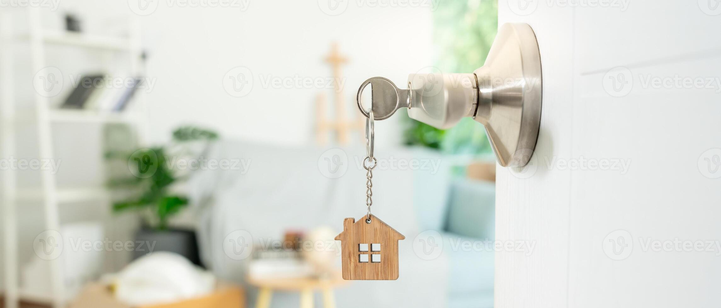 Moving house, relocation. The key was inserted into the door of the new house, inside the room was a cardboard box containing personal belongings and furniture. move in the apartment or condominium photo