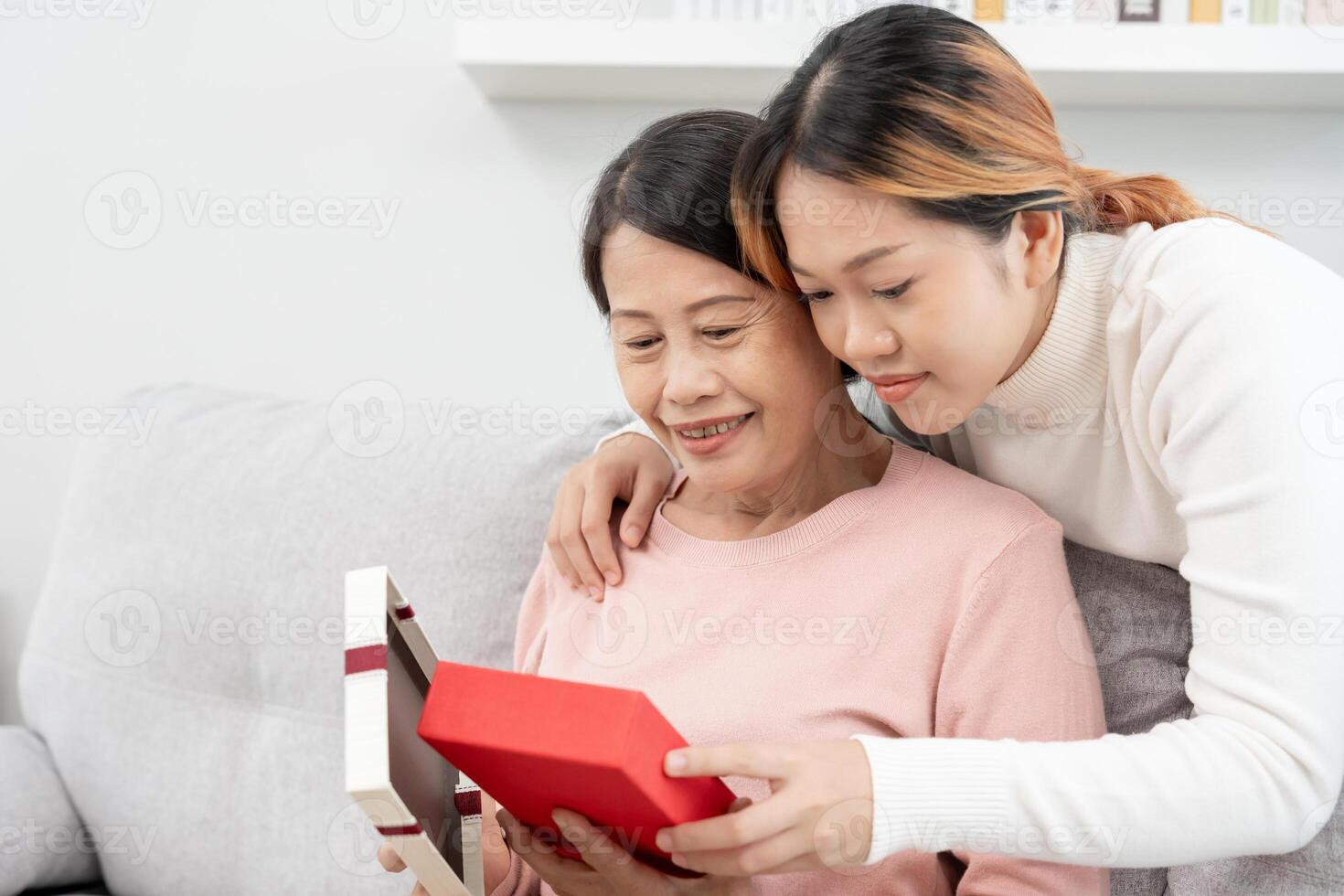 madre día, linda asiático adolescente niña dar regalo caja a maduro medio años mamá. amar, beso, cuidado, contento sonrisa disfrutar familia tiempo. celebrando especial ocasión, contento cumpleaños, contento nuevo años, alegre Navidad foto