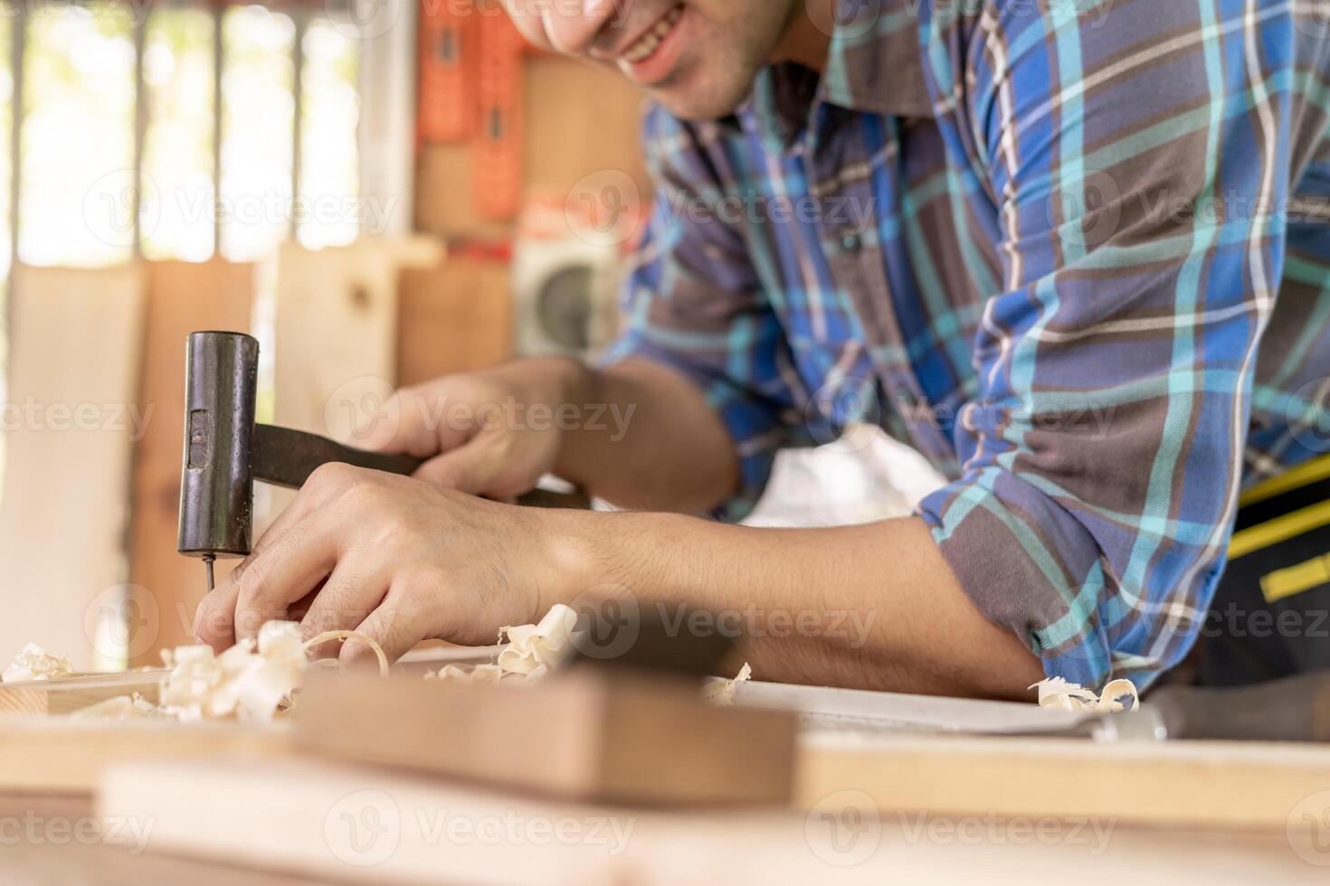 asiático hombre propietario un pequeño mueble negocio es preparando madera para producción. carpintero masculino es ajustar madera a el deseado tamaño. arquitecto, diseñador, incorporado, profesional madera, artesano, taller. foto