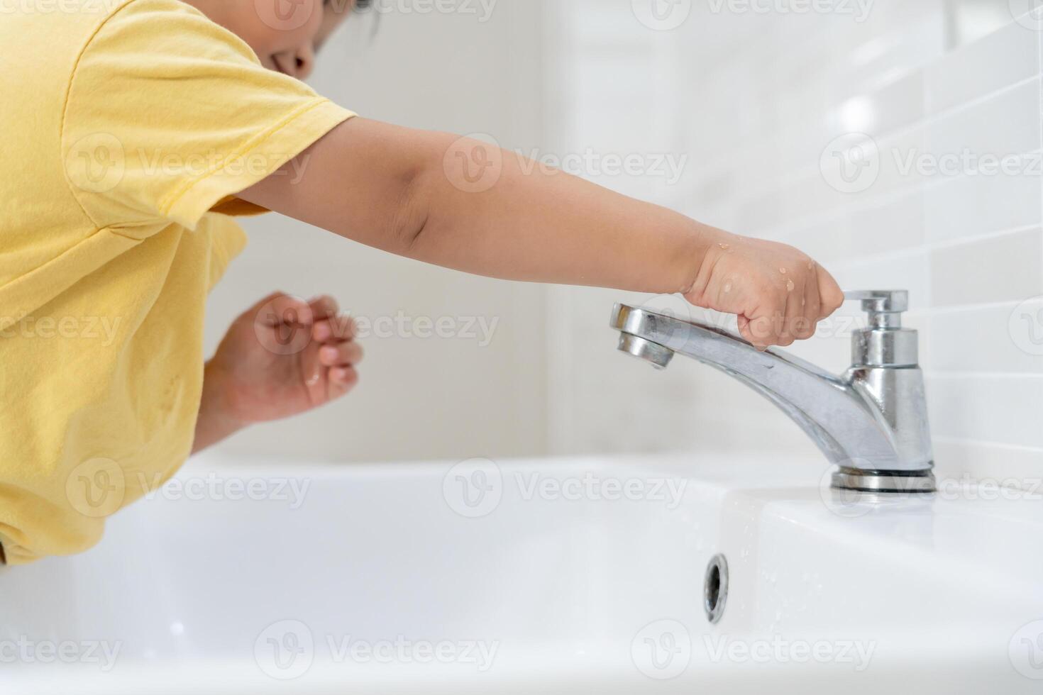 Save water. Little kid keeps turning off the running water in the bathroom to protect environment. Greening planet, reduce global warming, Save world, life, future, risk energy, crisis , water day. photo