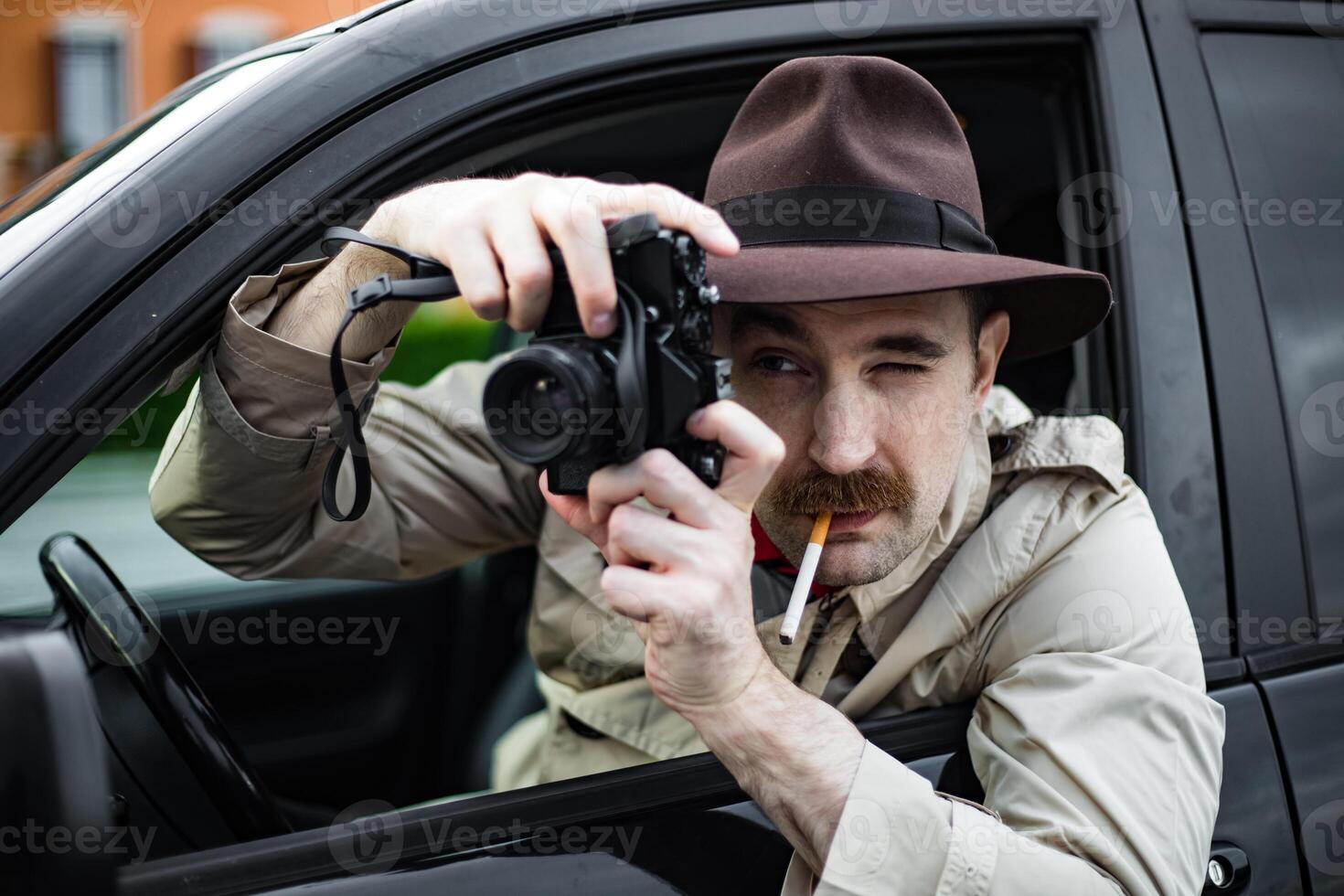 Detective smoking a cigarette in his car while spying someone with his camera photo