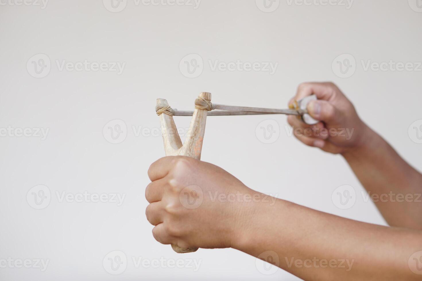 Close up hands hold wooden slingshot for playing shooting game. Concept , Thai traditional weapon that use to shoot birds, fish , for fight game or other purposes. photo