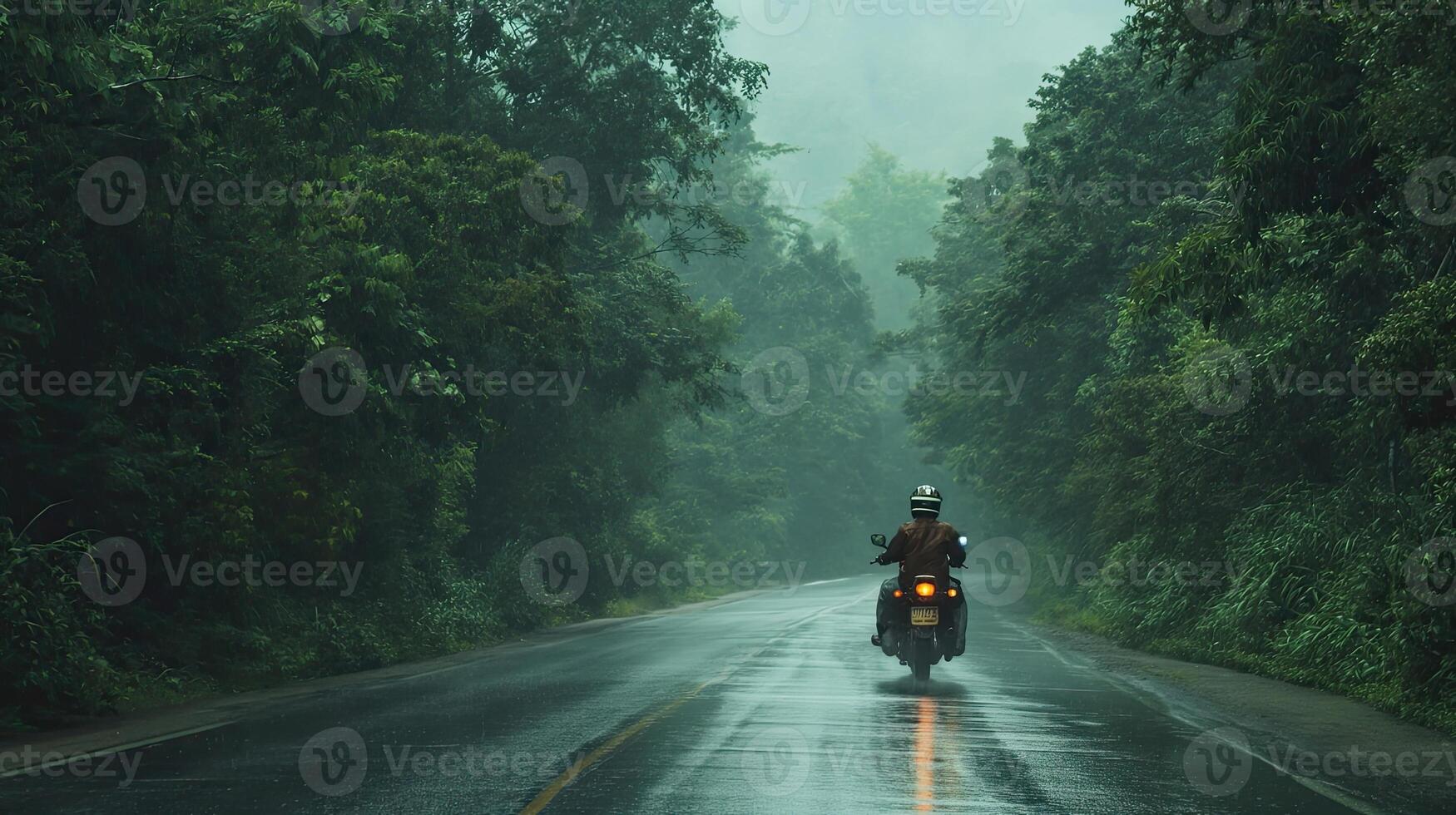 AI generated a motorbike driver navigating through the rain on a densely tree-lined road, the shimmering raindrops and lush foliage creating a captivating ambiance of nature's embrace photo