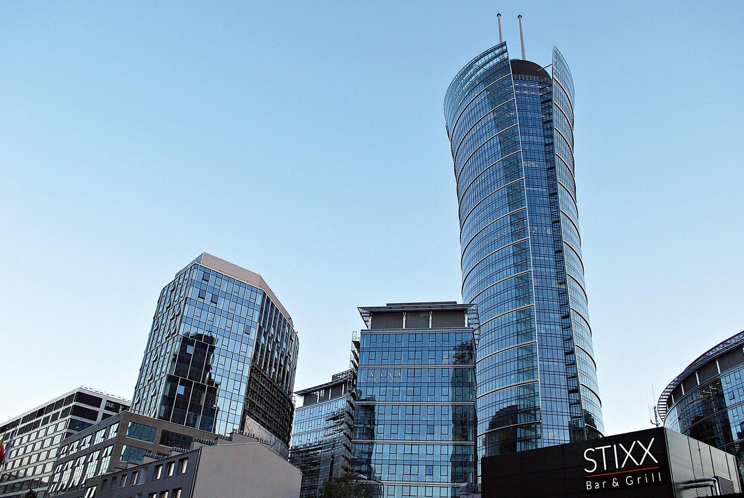 vaso edificio con transparente fachada de el edificio y azul cielo. estructural vaso pared reflejando azul cielo. foto